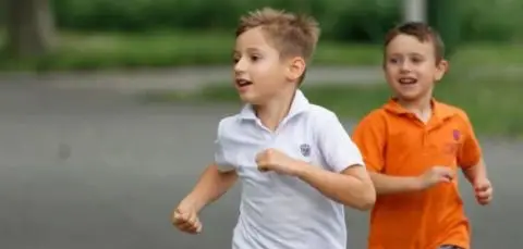 Dos nens corrents un darrere l'altre