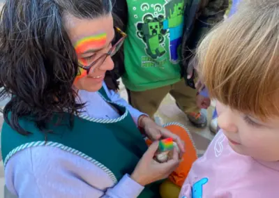 Monitora feliç pintant cara infant